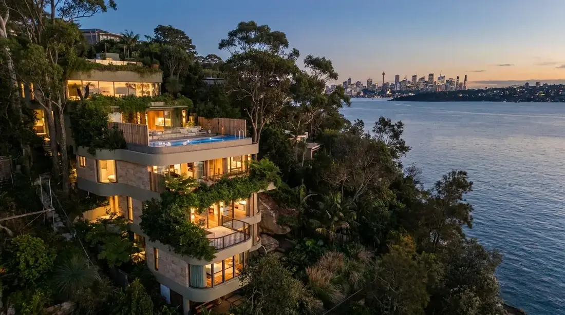 Wide aerial visualisation of the Harbour Hillside Residence showing the steep, treed waterfront headland the six-level split-level design responds to