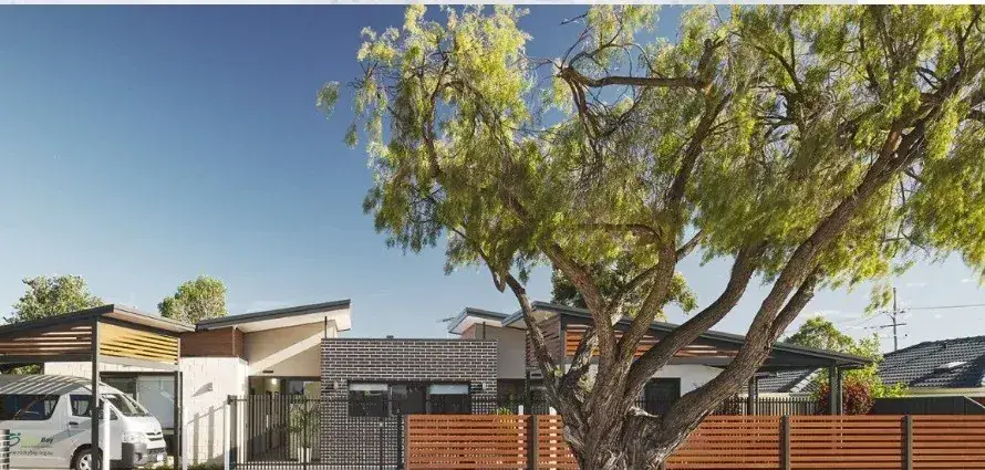 Completed single-storey group home with a wide accessible carport, level driveway and screened front fence