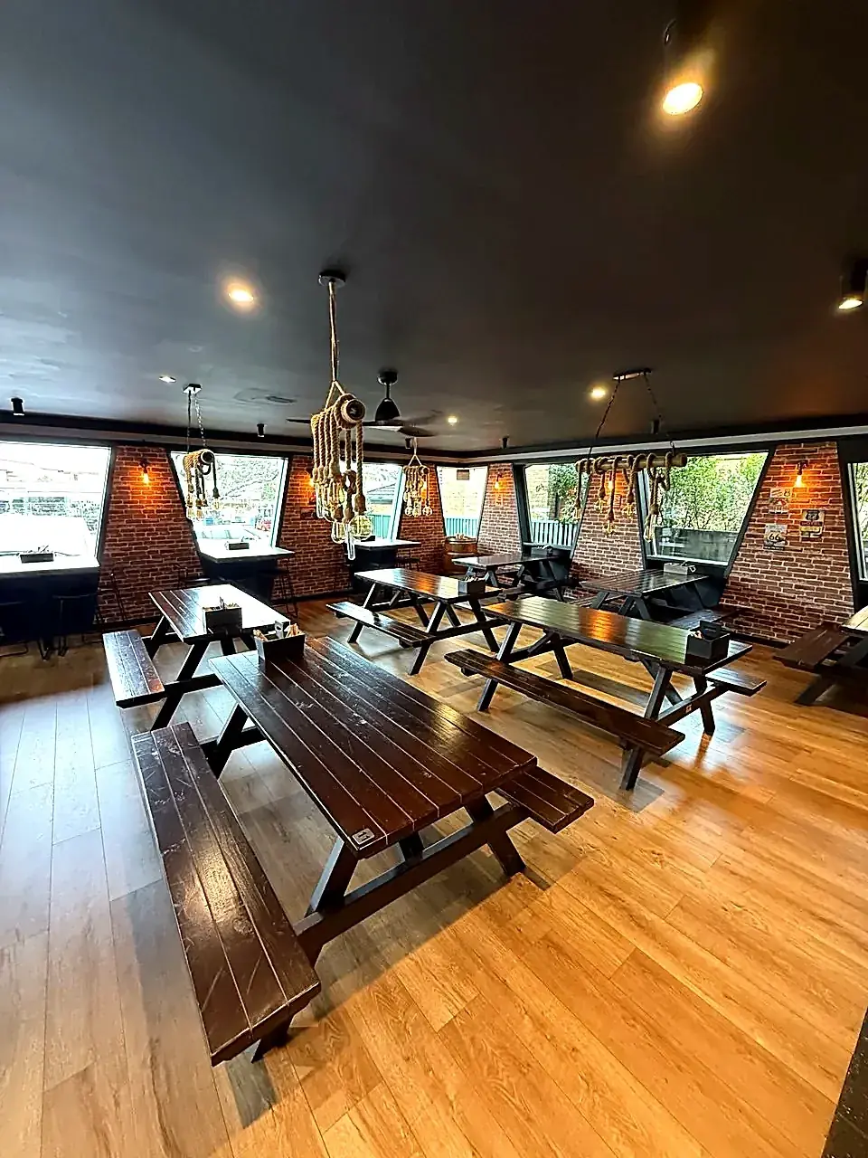 Main dining room with picnic-bench seating and rope pendant lighting
